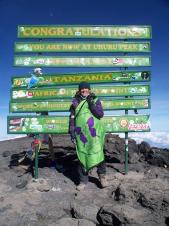 Michele fly's the JHMT flag at the summit of the highest free standing mountain in the world!